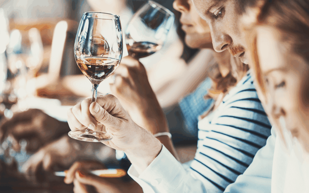 hands holding glasses of different types of wine